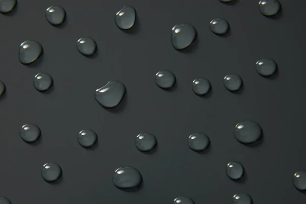 水滴在灰色背景上 宏观上 气泡闭合 化妆品保湿液滴 平铺图案上 — 图库照片