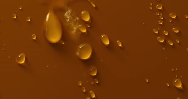 金青铜背景上的水滴 宏观水滴 气泡闭合水滴 化妆品保湿液滴 平铺花纹 — 图库视频影像
