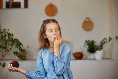 Küçük kız yiyecekleri karşılaştırıyor, tatlı pastaya karşılık mikro yeşili seçiyor sağlıklı beslenme alışkanlığı, doğru beslenme konsepti, doğru seçilmiş yiyecek.