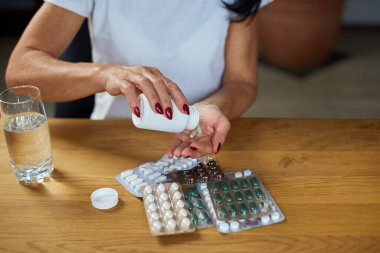 Olgun hasta kadının antibiyotik alması grip, soğuk ya da mevsimsel virüs, sağlık ve tedavi konseptinden aldığı aspirin hapları.
