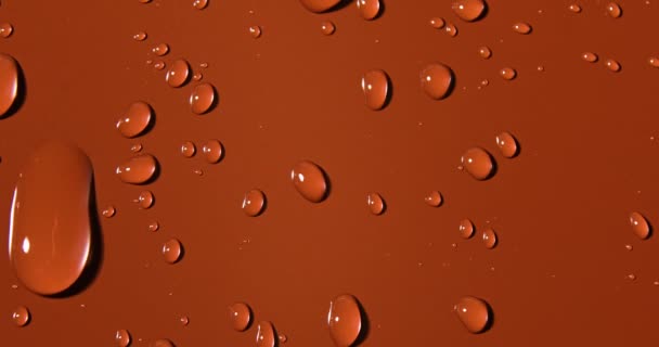 水滴在褐色背景上 宏观上 气泡闭合 化妆品保湿液滴 平坦的铺盖图案上 — 图库视频影像