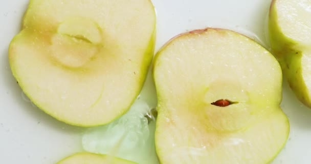 白い背景にゲルで回転新鮮なスライスされたリンゴのトップビュー ジュースとゲル血清 有機化粧品 抽出物 — ストック動画