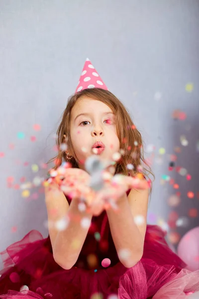 Piękna Dziewczynka Wysadza Powietrze Kolorowe Konfetti Bawiąc Się Domu Urodziny — Zdjęcie stockowe