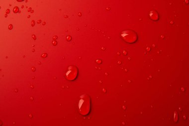 Kırmızı arkaplanda soyut su damlaları, makro, baloncuklar yaklaşın, kozmetik sıvı damlaları, düz döşeme deseni.