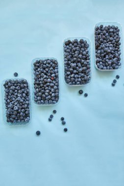 Mavi arka planda bir kutuda taze organik, sulu yabanmersini yatağı, üst manzara, kopyalama alanı. Sağlıklı beslenme, antioksidan, vitamin, yaz yemeği kavramı.