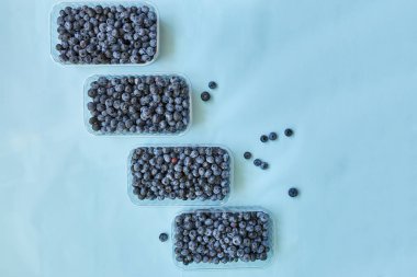 Mavi arka planda bir kutuda taze organik, sulu yabanmersini yatağı, üst manzara, kopyalama alanı. Sağlıklı beslenme, antioksidan, vitamin, yaz yemeği kavramı.