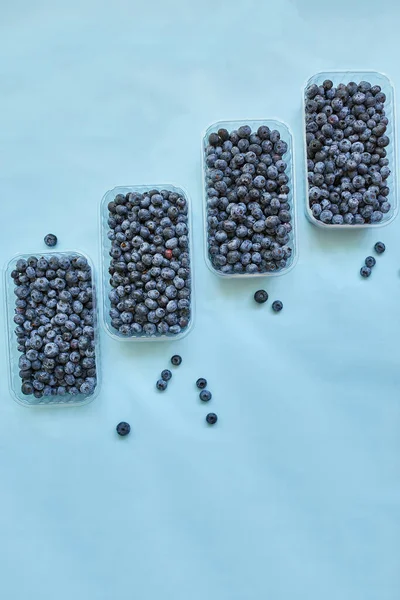 Mavi arka planda bir kutuda taze organik, sulu yabanmersini yatağı, üst manzara, kopyalama alanı. Sağlıklı beslenme, antioksidan, vitamin, yaz yemeği kavramı.