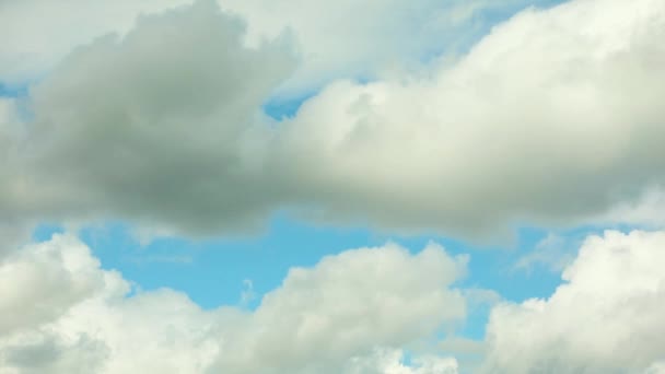 Weiße Wolken fliegen über einen strahlend blauen Himmel — Stockvideo
