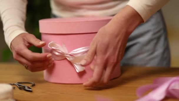 Handen Van Onherkenbare Vrouw Wikkelen Met Lint Een Roze Cadeau — Stockvideo