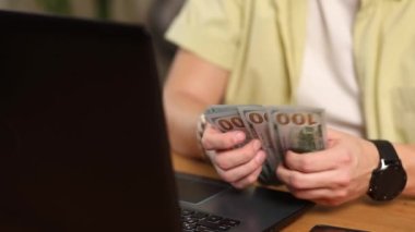 Erkek elleri kapalı para saymak Amerikan doları banknotlar, masada oturmak, gelir ve iş konsepti