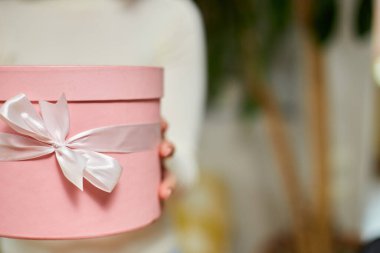 Kadın el ele tutuşması, beyaz kurdeleli pembe hediye hediye, hediye kutusu, noel hediyesi veya diğer el yapımı hediyeler, yavaş çekim