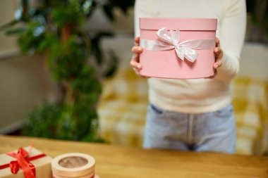 Kadın el ele tutuşması, beyaz kurdeleli pembe hediye hediye, hediye kutusu, noel hediyesi veya diğer el yapımı hediyeler, yavaş çekim