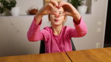 Little girl, making hearts from hands, love, casual cheerful cute funny girl showing heart shape sign with fingers