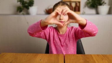 Little girl, making hearts from hands, love, casual cheerful cute funny girl showing heart shape sign with fingers