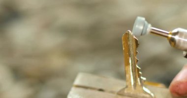 Atölyedeki çilingir yeni anahtar yapıyor. Öğütme makinesini kullanın. Kopya metal anahtar üretimi..