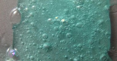 Mavi krem sıvı jel serumu gümüş dokuya, makyaj ve kozmetik arka plana, cilt ürününe veya saç ürününe yayılır