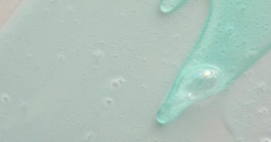 Mavi krem sıvı jel serumu gri doku, makyaj ve kozmetik arka plan, cilt bakımı veya saç ürünü üzerine akmaktadır.