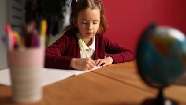 Konzentrierte Schulmädchen Sitzen Schreibtisch Und Machen Hausaufgaben Hausaufgabenbetreuung Kleine Juniormädchen — Stockvideo