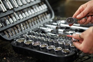 İnsan, atölyedeki farklı metal başlıklar ve bitler, değiştirilebilir tornavida seti, çalışma araçları ile el ile set kutusunu açar.