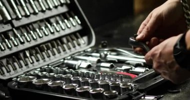 İnsan eli, atölyedeki farklı metal başlıklı ve biti tipli set kutusundan çalışma araçlarını alır, değiştirilebilir tornavida seti.