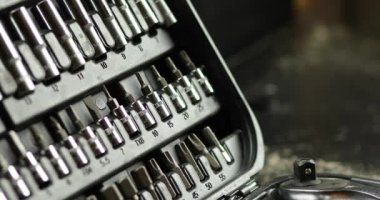 İnsan eli, atölyedeki farklı metal başlıklı ve biti tipli set kutusundan çalışma araçlarını alır, değiştirilebilir tornavida seti.