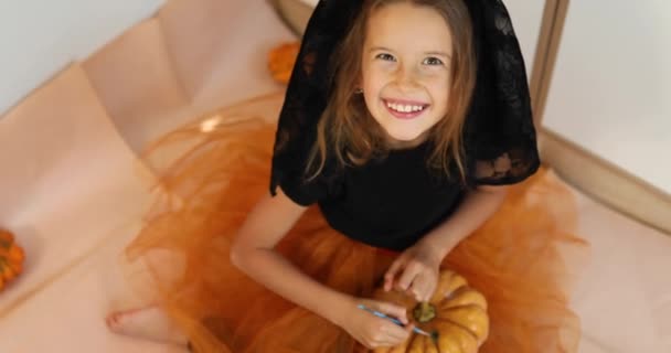 Criança Feliz Decorando Uma Abóbora Casa Menina Desenho Rosto Laranja — Vídeo de Stock