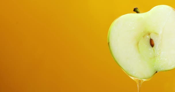 Капание Яблочного Сока Свежего Нарезанного Зеленого Яблока Выделенного Желтом Фоне — стоковое видео