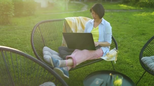 Frilansande Kvinna Arbetar Laptop Hemma Trädgården Begreppet Distansarbete Från Bekväm — Stockvideo