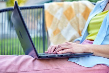 Bilgisayarda uzaktan çalışan bir kadın el bilgisayarı, laptopla çalışan serbest çalışan bir kadın, sosyal medyayı kontrol eden, internetten alışveriş yapan, bahçedeki arka bahçede eve sipariş veren bir kadın.