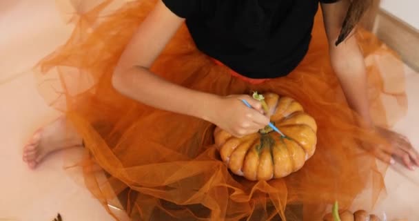 家でカボチャを飾る幸せな子供オレンジのハロウィンジャック ランタンカボチャに顔を描く小さな女の子 休日の装飾コンセプト — ストック動画