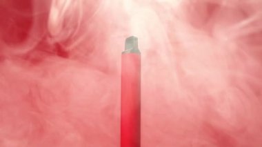 Tek kullanımlık kırmızı bir e-sigaranın rotasyonu ve dumanla doluyor. Kötü alışkanlıklar, modern sigara içme elektronik sigara kavramı..