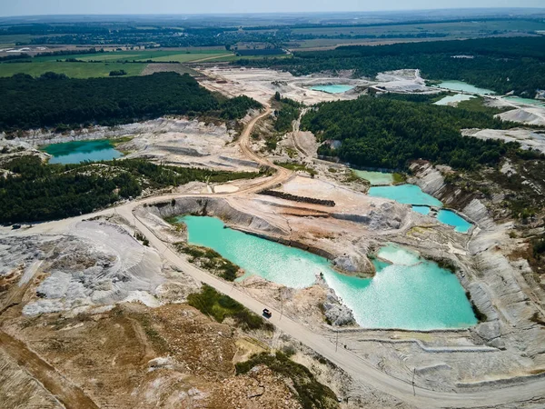 Aerial view quarry extraction porcelain clay, kaolin, with turquoise water and white shore, drone view open pit mine kaolin flooded with water