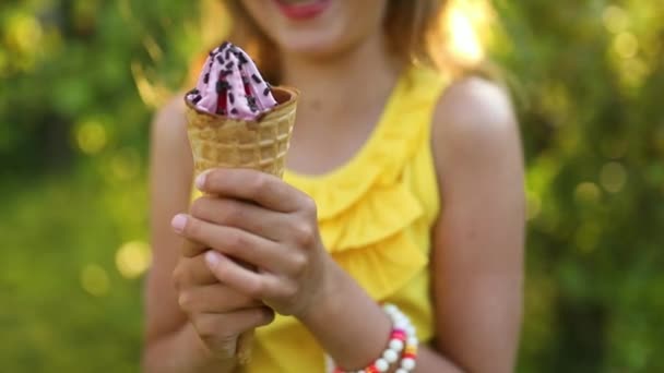 夏の日に公園で休んでいる間にイタリアのアイスクリームコーンの笑顔を食べるブレースを持つ幸せな女の子 子供はアイスクリーム屋外 幸せな休日 夏を楽しんでいます — ストック動画