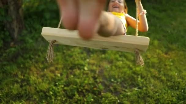 快乐赤脚笑着的小女孩在夕阳西下的夏日里在自家后院荡秋千 夏天在户外度假 — 图库视频影像