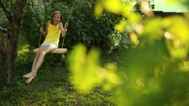 행복하게 맨발로 소녀는 여름에 뜰에서 그네를 여름날 야외에서 휴가를 보내는 — 비디오