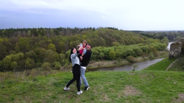 幸せな家族は海岸にスマートフォンで自撮りスラフ川の丘 Gubkiv村ウクライナの旅行先 — ストック動画