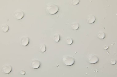 Gri arkaplanda soyut su damlaları, makro, baloncuklar, yakın plan, kozmetik sıvı damlaları, düz döşeme deseni.