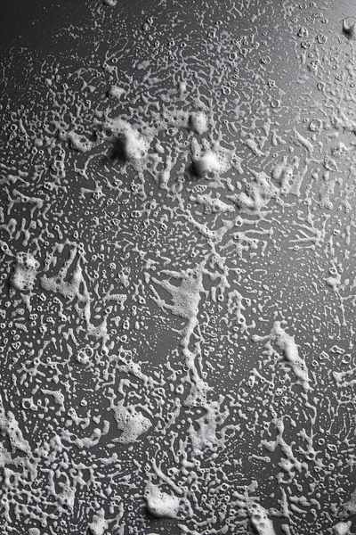 泡の抽象的な灰色の背景を持つ白い石鹸泡のテクスチャ シャワージェル シャンプー 顔クリームクレンジングムースサンプル — ストック写真