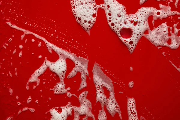 泡の抽象的な赤の背景と白い石鹸泡のテクスチャ シャワージェル シャンプー 顔クリームクレンジングムースサンプル — ストック写真