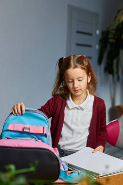 Liseli kız evde sırt çantasına kitap ve notlar koydu, öğrenci personeli eğitime hazırladı, okul malzemelerine, okula dönüş konseptine..