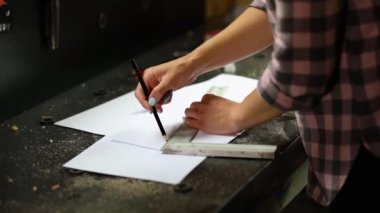 Kadın iç mimar çizimler üzerinde çalışıyor, kadın mimar atölyede yeni daire tasarımı cetvel planı çiziyor, yeni inşaat projesinin tasarım projeleri.