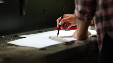 Female interior designer working on drawings, woman architect draws with ruler plan of new apartment design at workshop, design project blueprints for new construction project