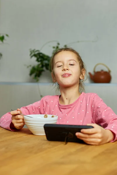 Девочка Ест Хлопья Молоком Смотрит Видео Смартфоне Вкусная Здоровая Пища — стоковое фото