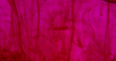 Close up of pink bubble serum poured in a medical glass, background, natural essential oil, cosmetic, medicine.