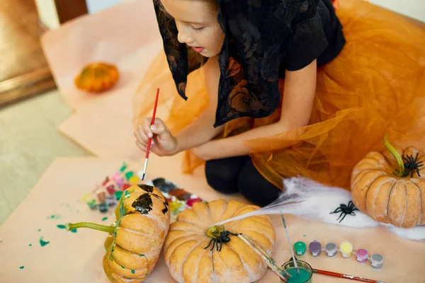 小女孩在橙色万圣节前夕画了脸杰克 奥灯南瓜 快乐的孩子在家里装饰南瓜 假日装饰概念 — 图库照片