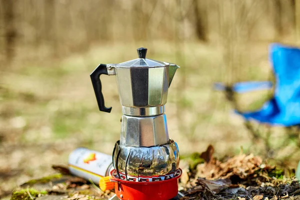 Making camping coffee from a geyser coffee maker on a gas burner,, autumn outdoor. Male prepares coffee outdoors, travel activity for relaxing, bushcraft, adventure, travel, tourism and camping concept