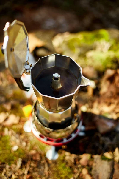 Making camping coffee from a geyser coffee maker on a gas burner,, autumn outdoor. Male prepares coffee outdoors, travel activity for relaxing, bushcraft, adventure, travel, tourism and camping concept