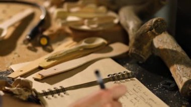 Close up of carpenter woman hand makes notes of order details with her customer at workshop, Creating craft handmade souvenirs, female in workshop.