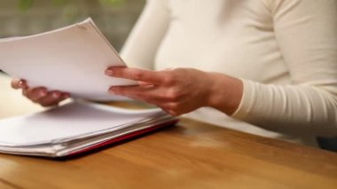 Çalışan iş kadını, arama yapmak için kağıt yığınları içinde çalışır. Ofisinde bir sürü evrakla çalışan bir kadın..