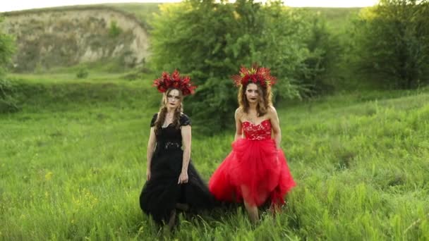 Hermosas Mujeres Brujas Largos Vestidos Rojos Negros Flores Aro Paseo — Vídeo de stock